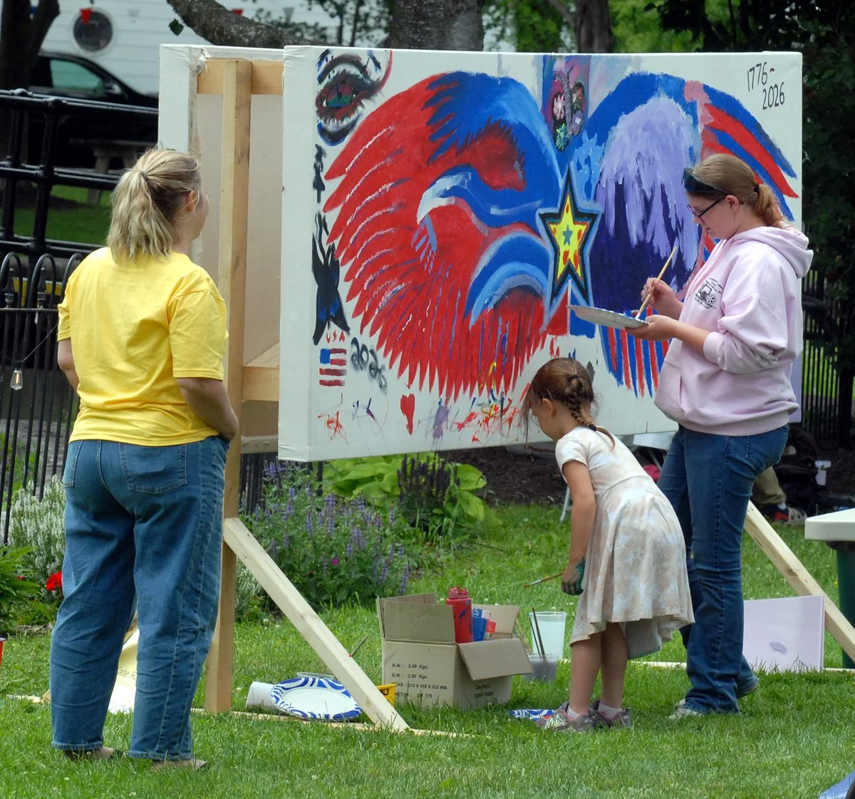 Community members add to CPI's patrotic red, white, and blue mural.