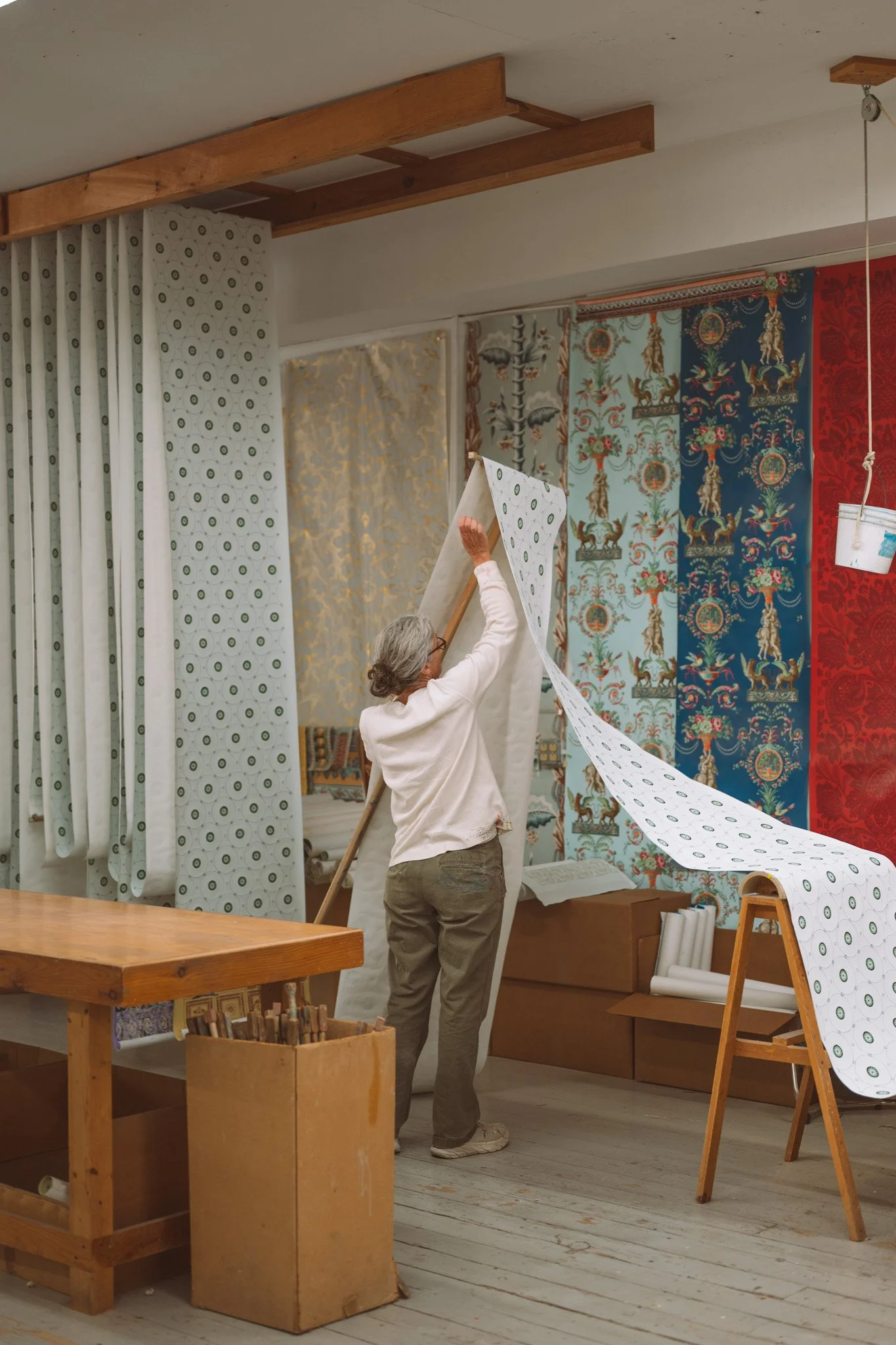 An employee hanging wallpaper at a wallpaper design shop in a small town in upstate New York