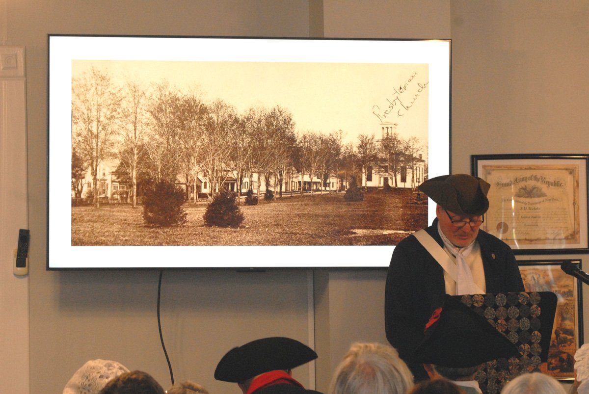 A Re volutionary reenacter in Judd Hall with a historic photo of Jefferson on the screen behind him.