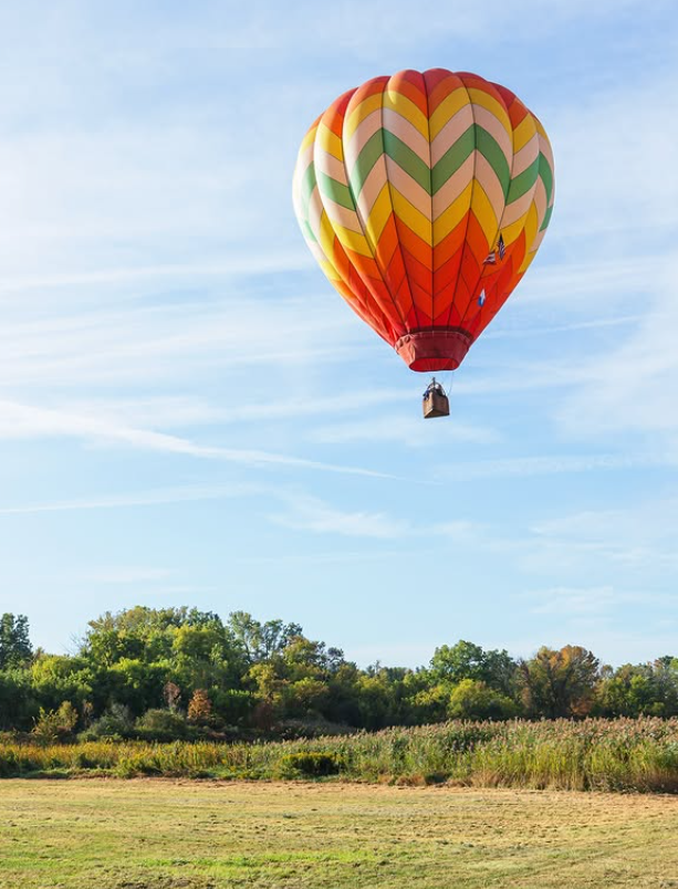 Hot air balloon flying above a meadow landscape in Schoharie County, one of the best places to live in Upstate New York