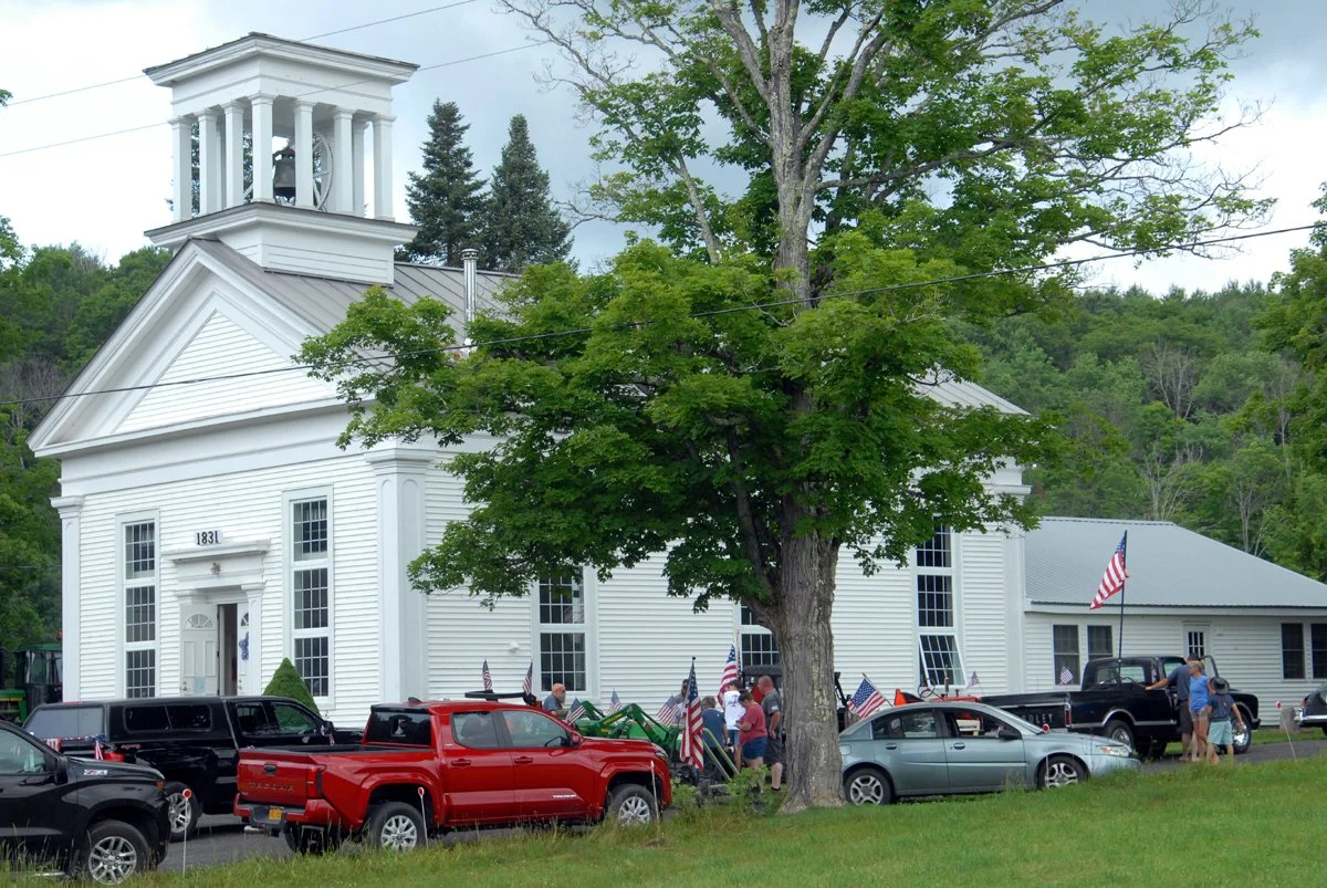 Cars and marchers line up in front of the Flat Creek Baptist Church for an old-fashioned July 4th parade and celebration.