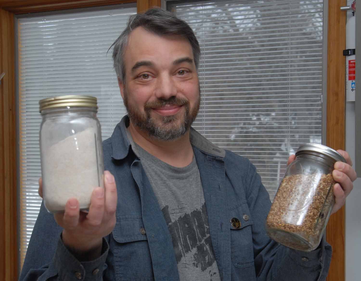 Agripreneur Brennan holding grain in his home in Schoharie County