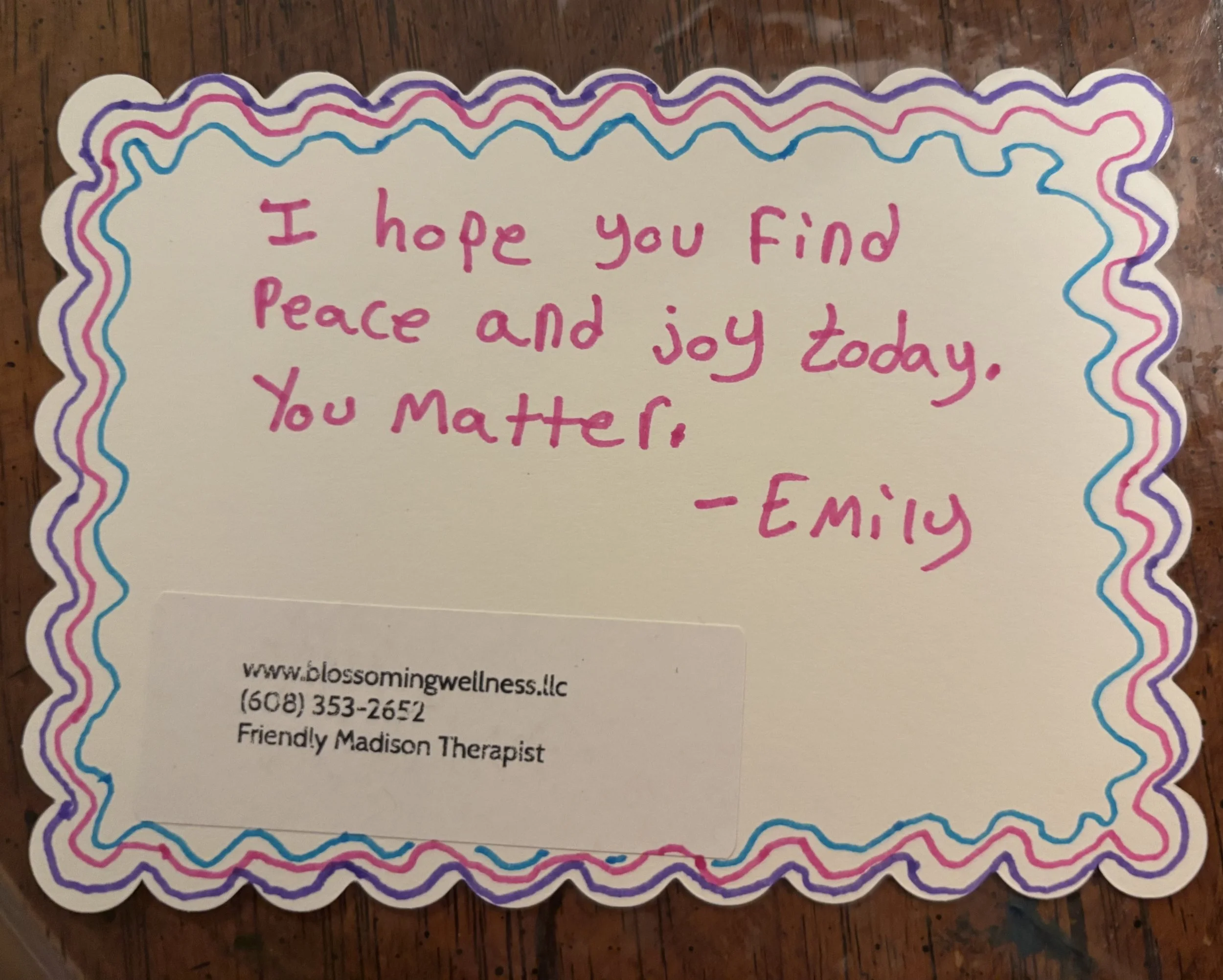 Colorful handwritten note with pink, blue, purple, and black decorative border, saying "I hope you find peace and joy today. You matter, -Emily".