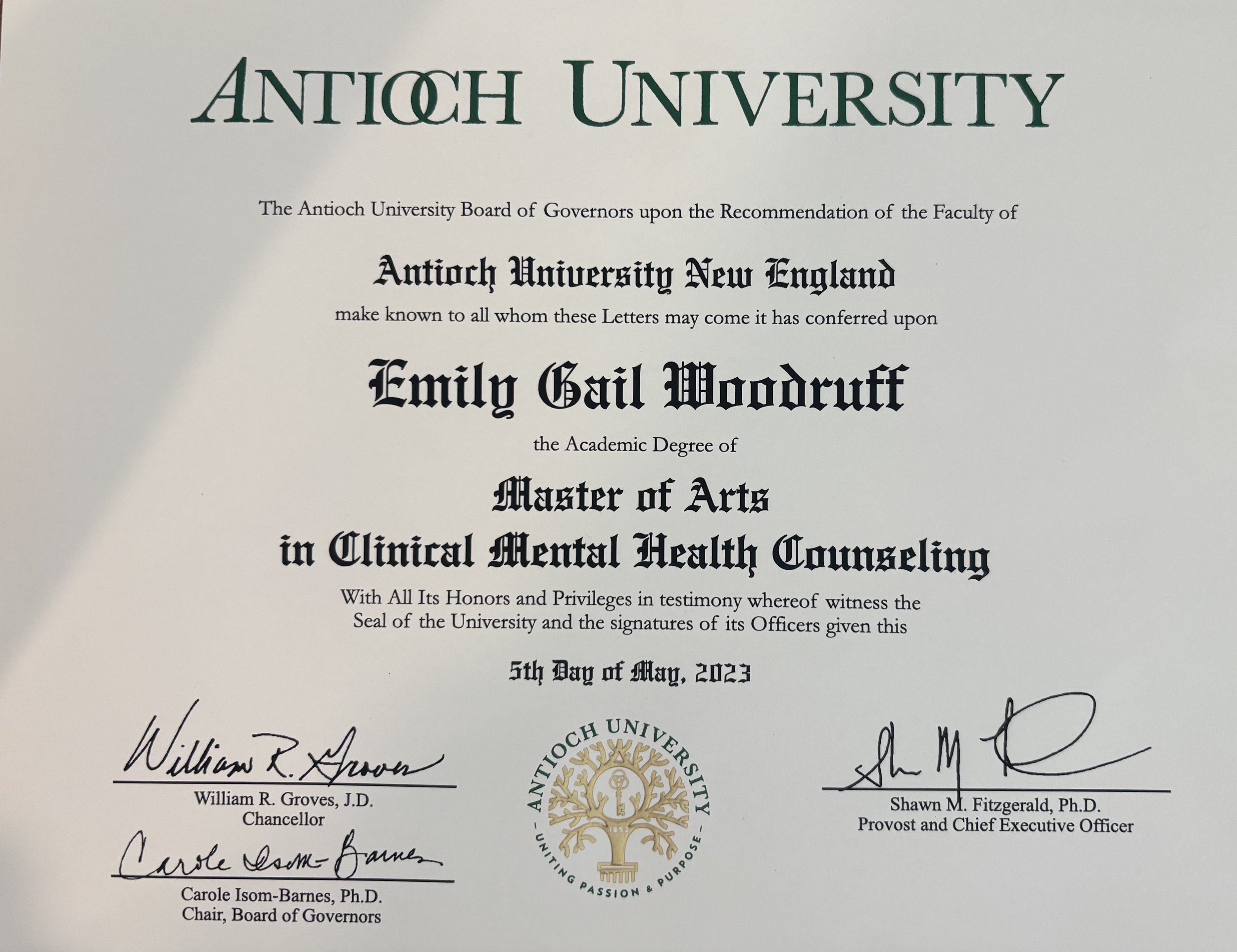 A diploma from Antioch University, awarded to Emily Gail Woodruff for her Master of Arts in Clinical Mental Health Counseling, signed by William R. Groves, William R. Groves, J.D., Carole Isom-Barnes, Ph.D., and Shawn M. Fitzgerald, Ph.D.