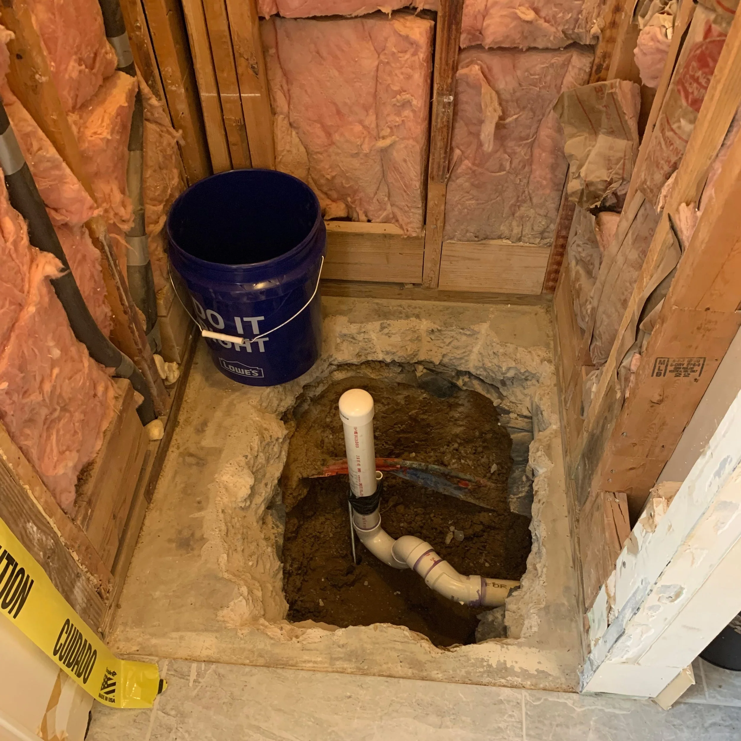 New shower drain rough-in with PVC trap and vent stack set in the concrete slab