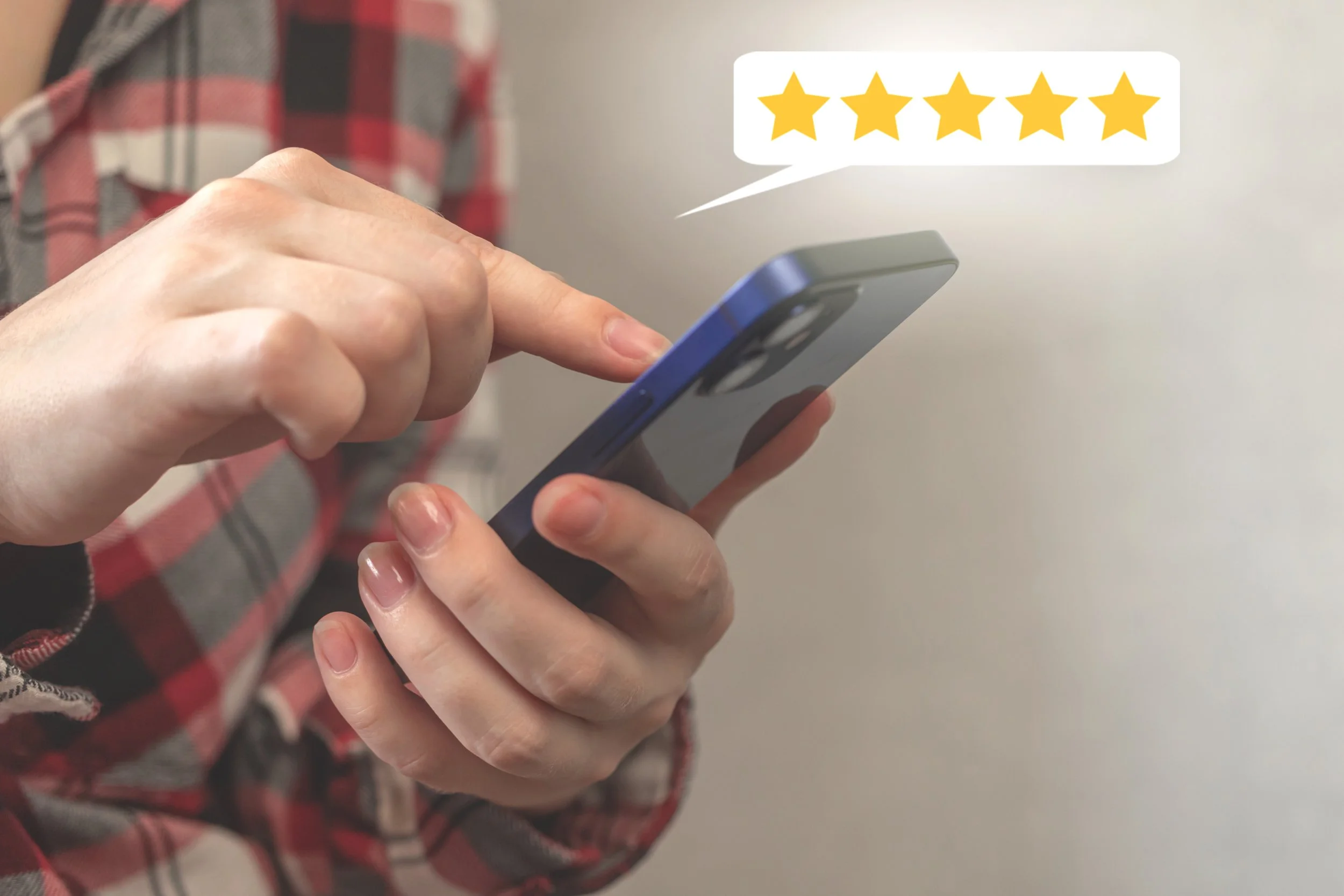Person holding a smartphone with a five-star review icon in a speech bubble above