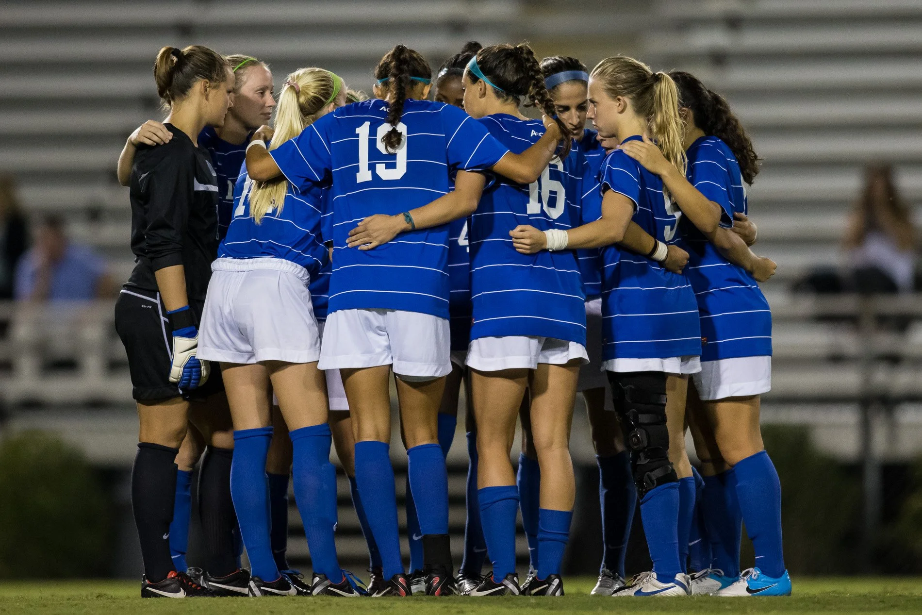 Women's soccer team huddle on field winning games college soccer recruiting