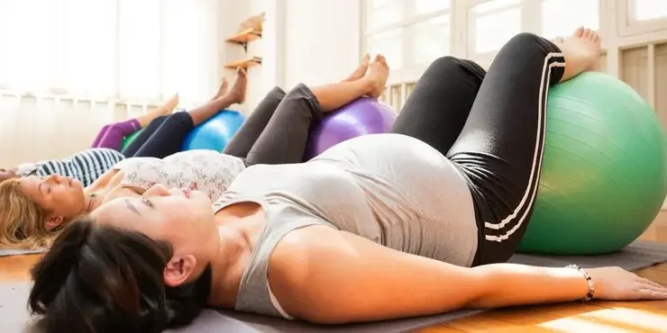 pregnant women exercising with fitness balls bright room diverse group women prenatal fitness relaxation health focus exercise wellness