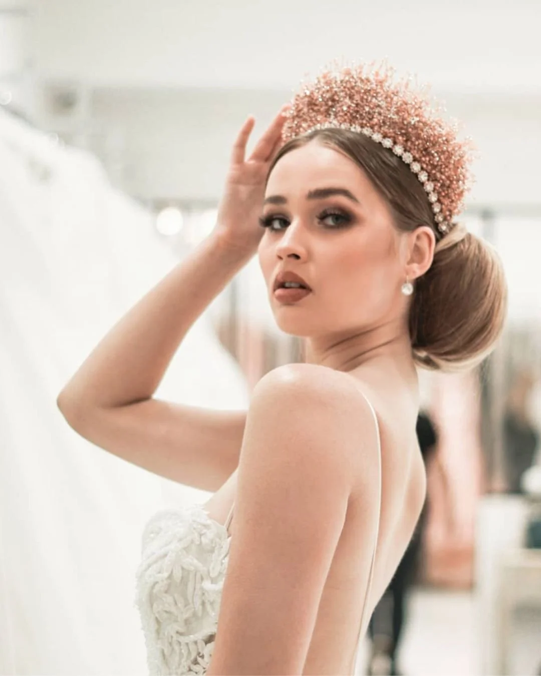 An bride wearing a backless wedding dress with a crown