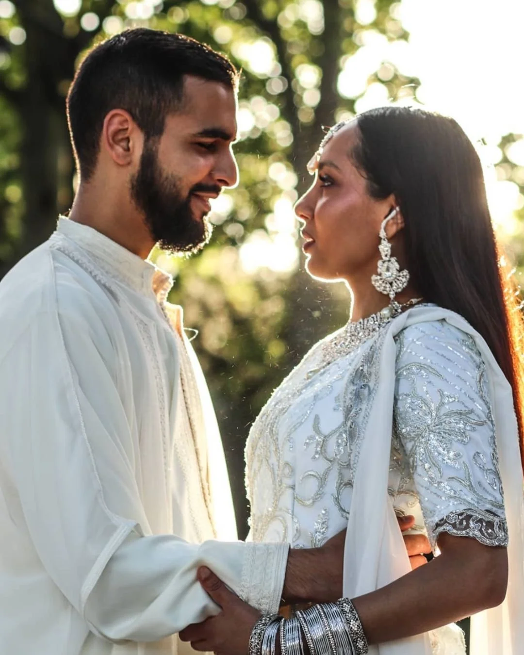 A wedding couple with traditional attires in the sun in the city of Paris.