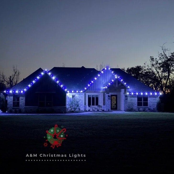 A house decorated with blue Christmas lights outlining the roof during dusk or early evening.