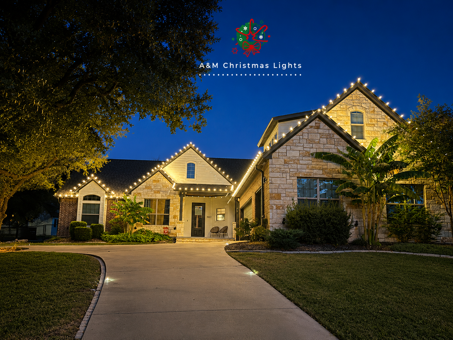 A house decorated with Christmas lights along its roofline and around its windows, with a landscaped front yard and driveway during evening time.