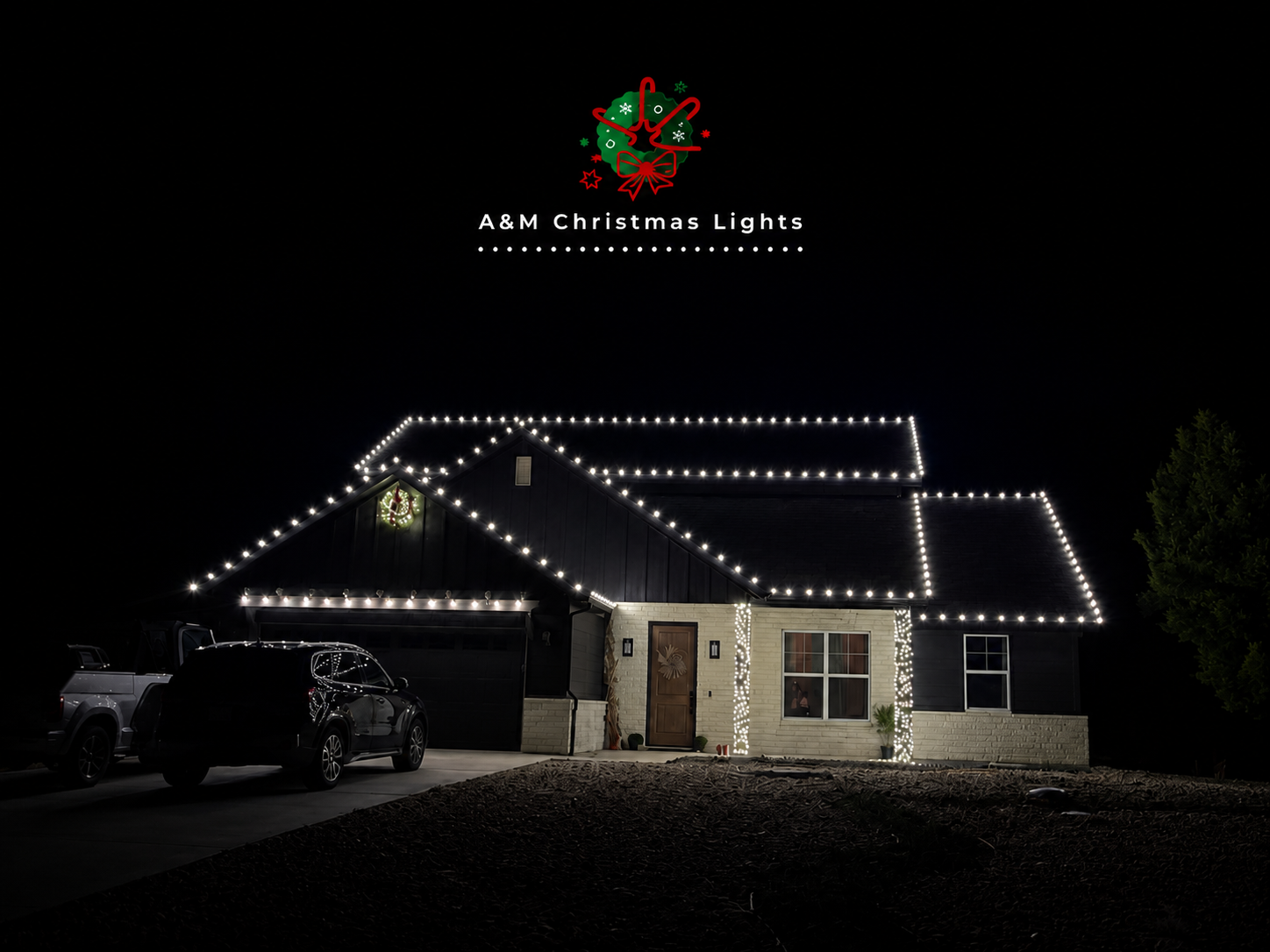 House decorated with Christmas lights outlining the roof and windows, with a wreath on the door, parked cars in front, and a logo for A&M Christmas Lights at the top.