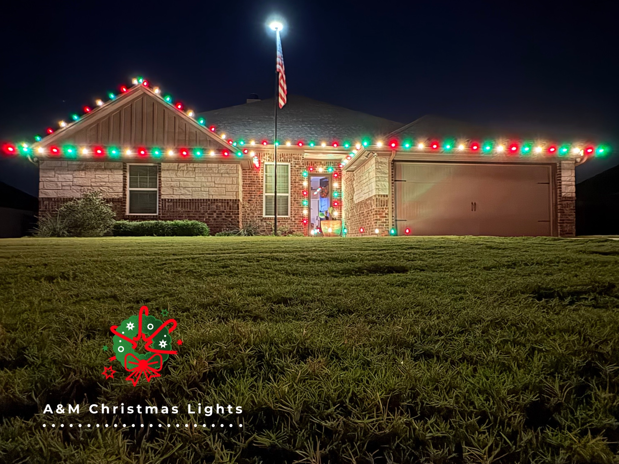A house decorated with colorful Christmas lights along the roofline and around the front door, with an American flag on a flagpole in front. The night sky is dark, and there's a lawn in the foreground. A graphic of Christmas ornaments, a bow, and hol