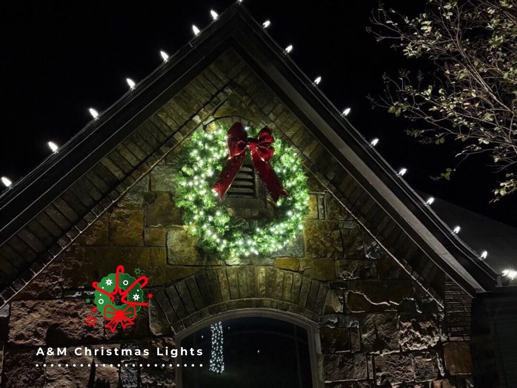 Decorated house with Christmas wreath and lights at night.