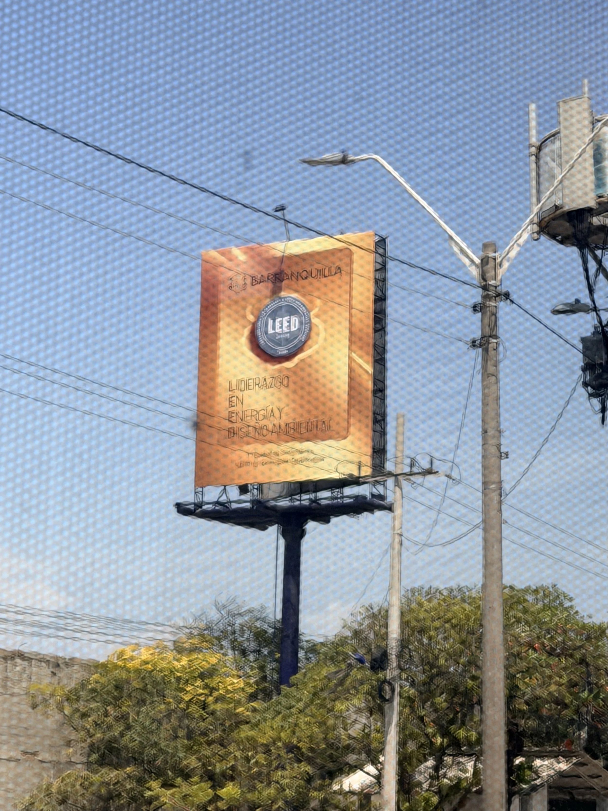  cartel publicitario en un poste de luz en una calle con árboles y cables eléctricos, en un día soleado y cielo azul