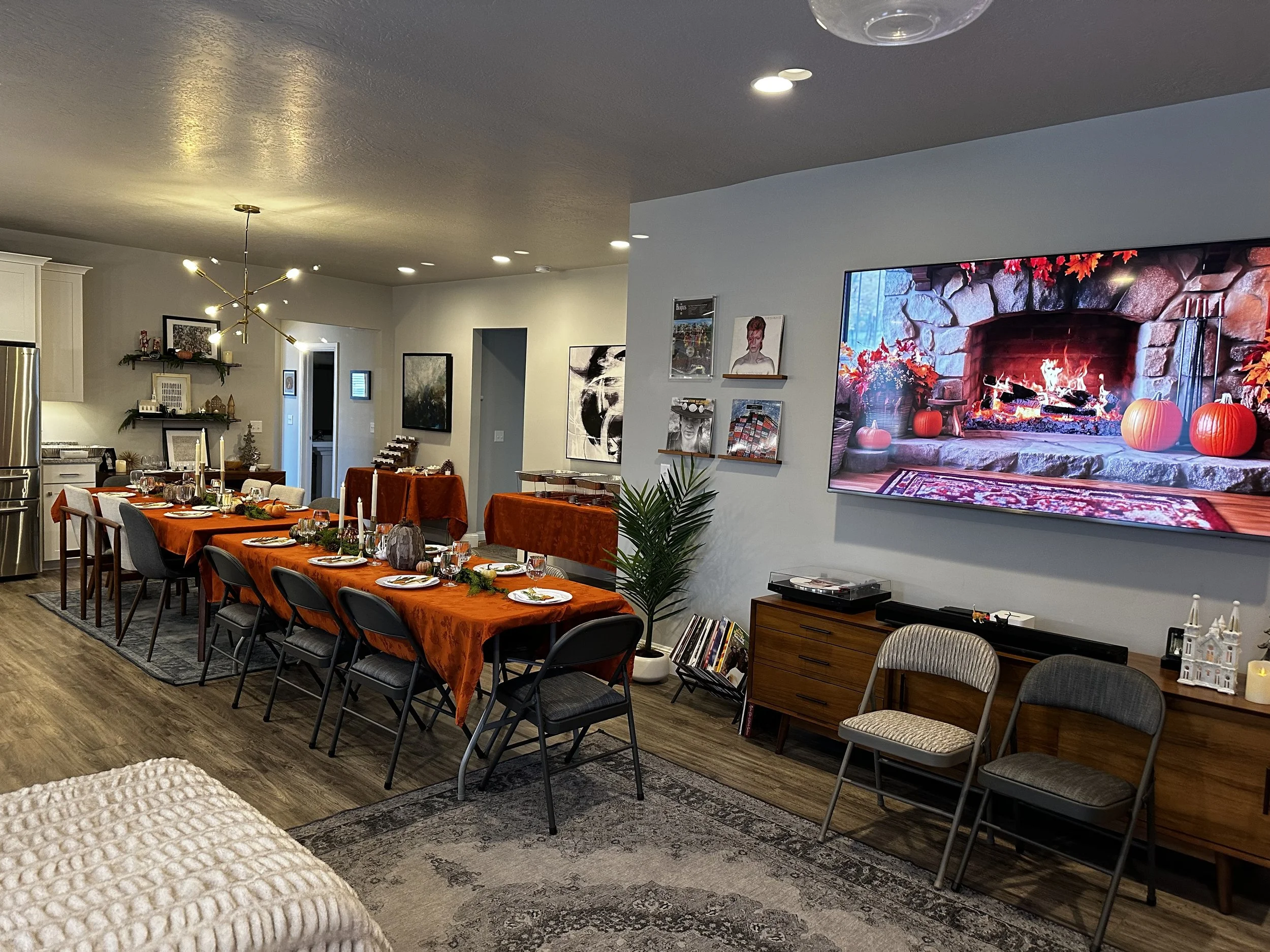 Entire table set up with all the place settings and a TV that has a YouTube video of a crackling fire