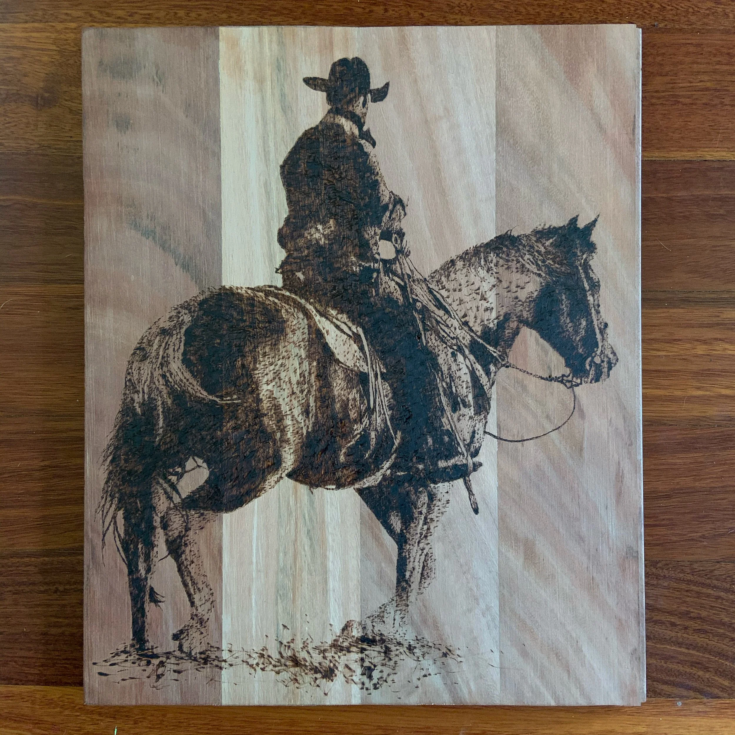 A detailed illustration of a cowboy riding a horse, depicted on a wooden panel with a background of vertical stripes.
