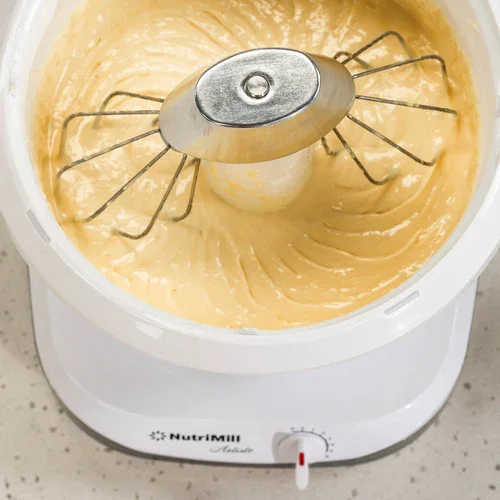 Electric ice cream maker with vanilla ice cream inside.