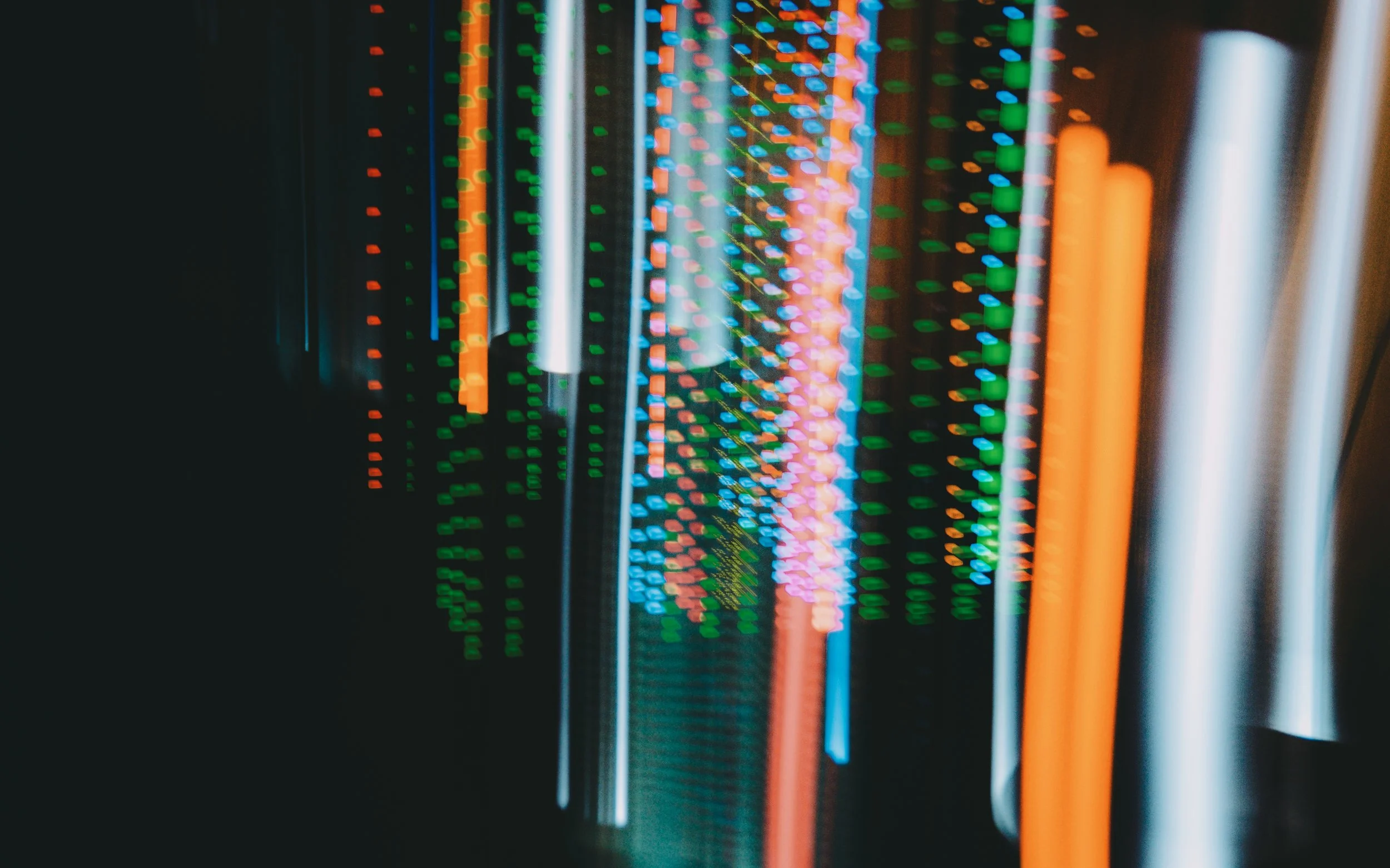 Close-up of a computer server rack with multicolored LED lights indicating data activity