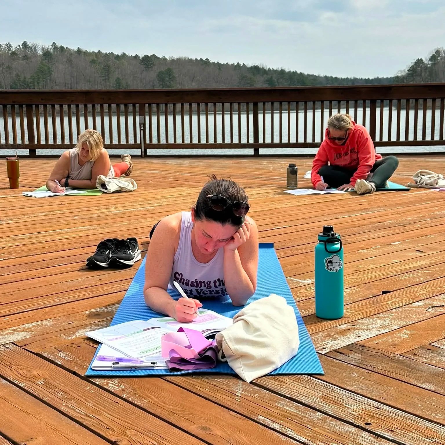 Woman journaling outdoors on a deck at a women's retreat at Trout Lodge in Potosi, MO