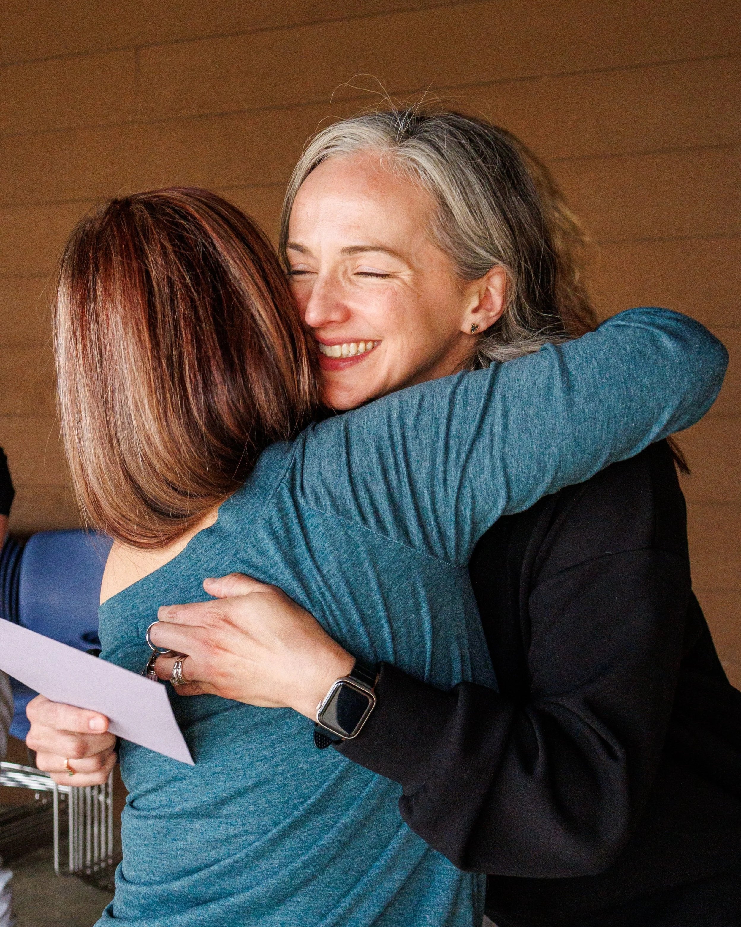 Two women in a warm embrace following the closing circle of a women's retreat near St. Louis, Missouri