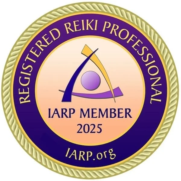 A circular badge with a purple and gold border, stating 'Registered Reiki Professional,' 'IARP Member 2025,' and 'IARP.org,' featuring a stylized logo with a purple circle, a blue swoosh, and a yellow and purple abstract figure.