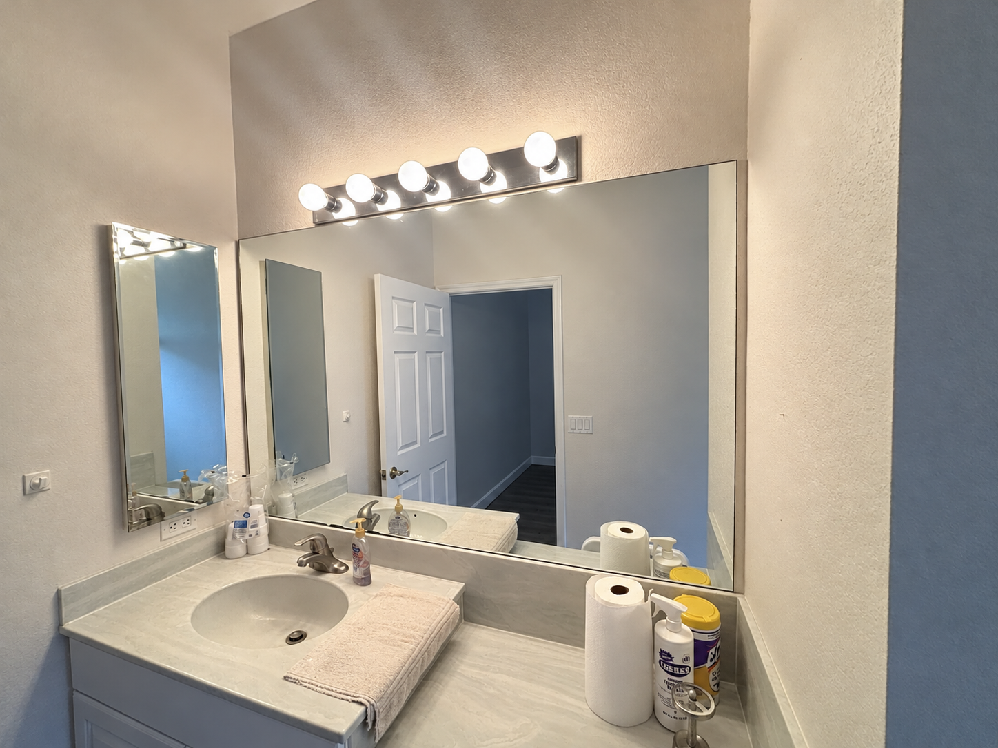 Bright Bathroom Vanity and Mirror Reflection.png