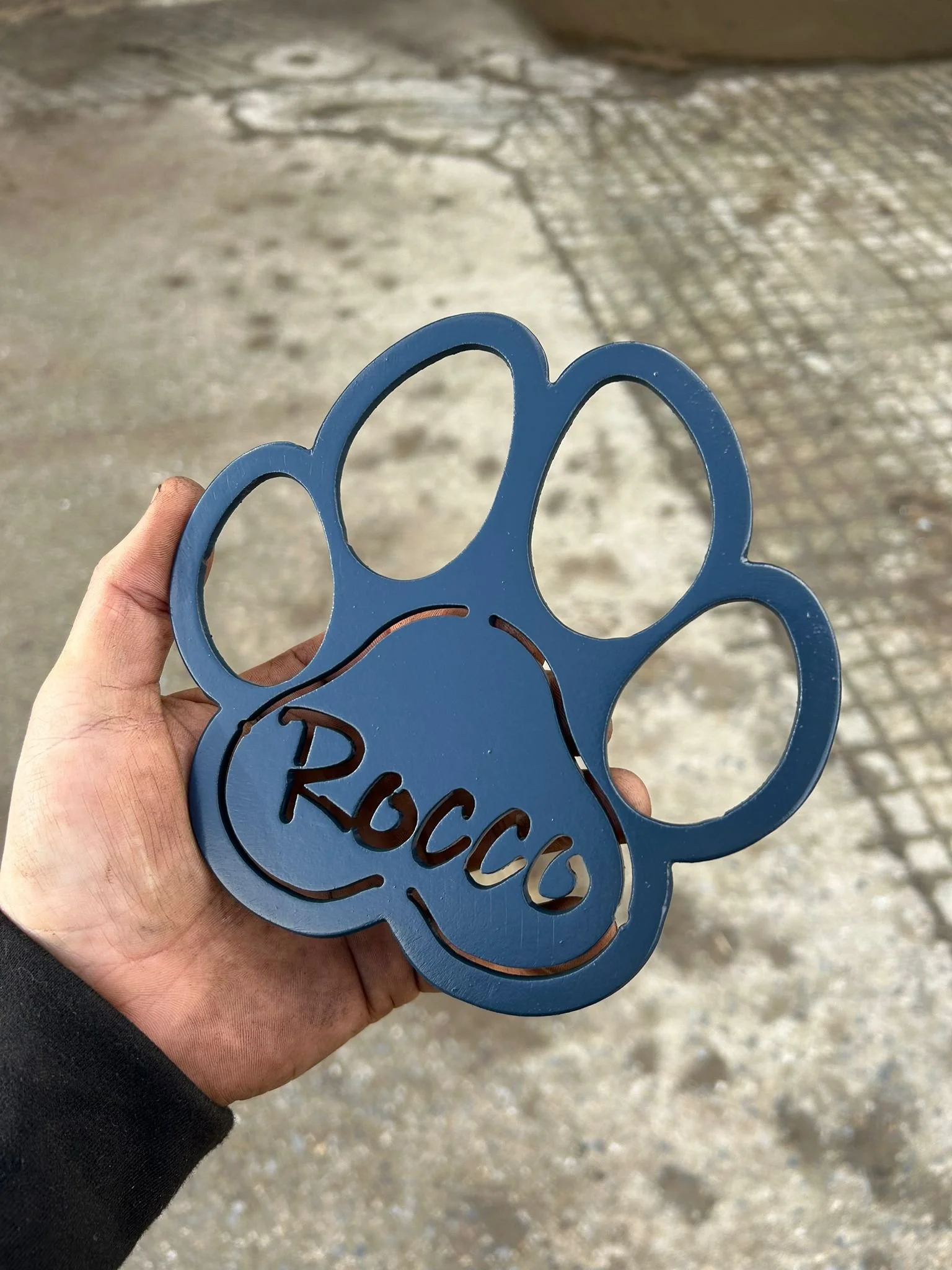 Black dog paw shaped sign, made from metal