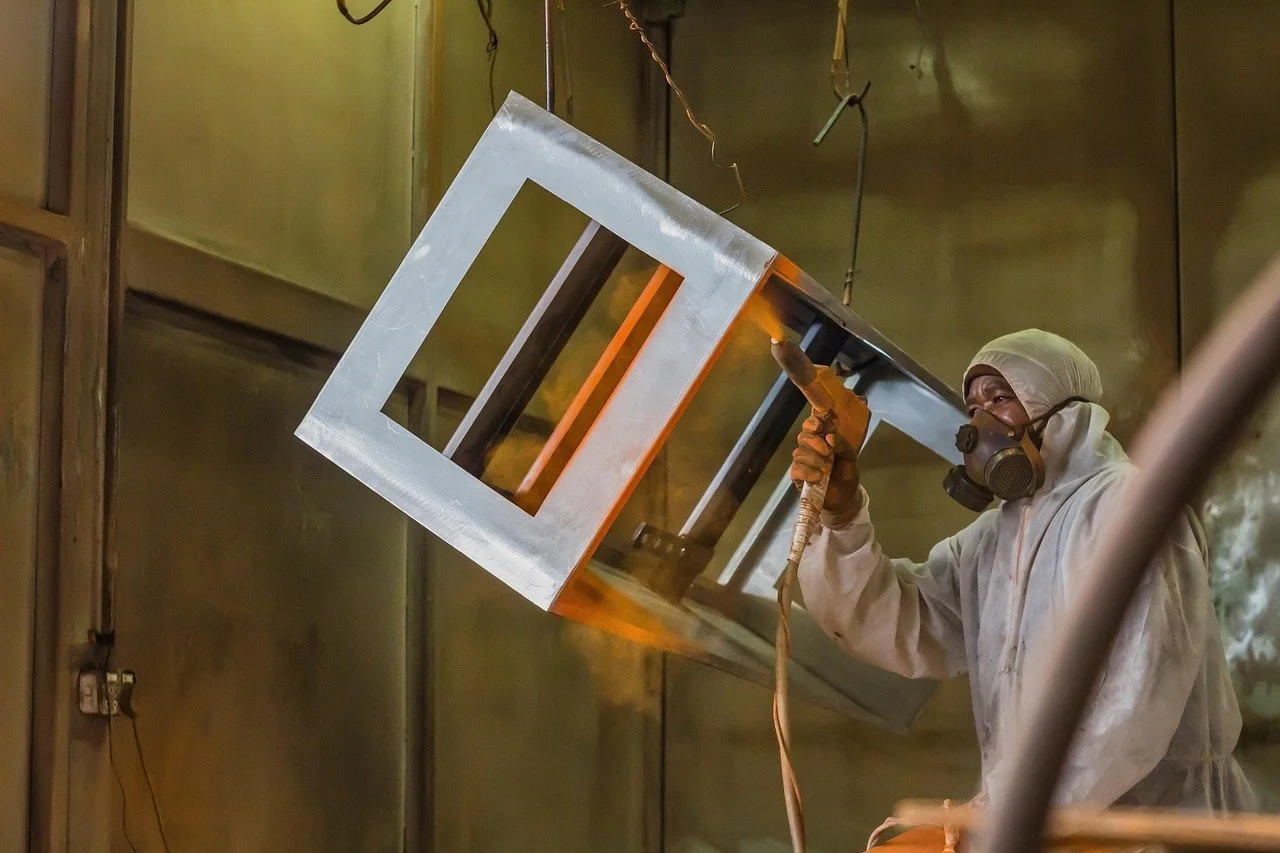 Man powder coating a steel object