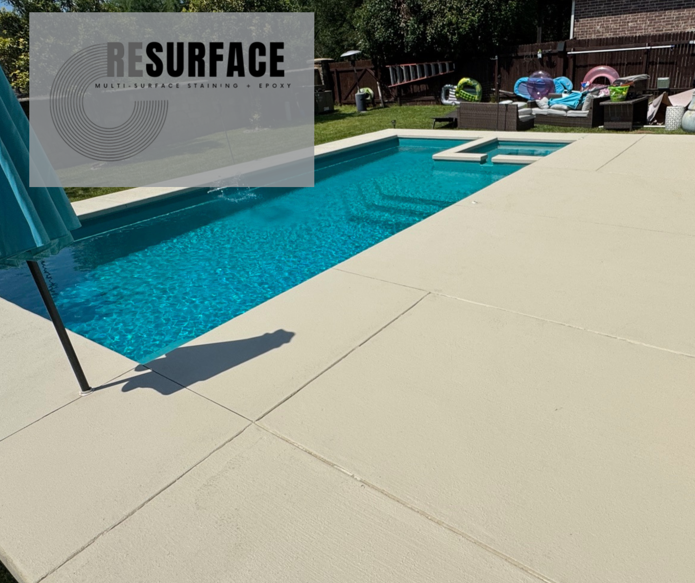 Backyard pool area with a rectangular swimming pool and a hot tub, surrounded by a concrete deck, with outdoor furniture and pool toys in the background.