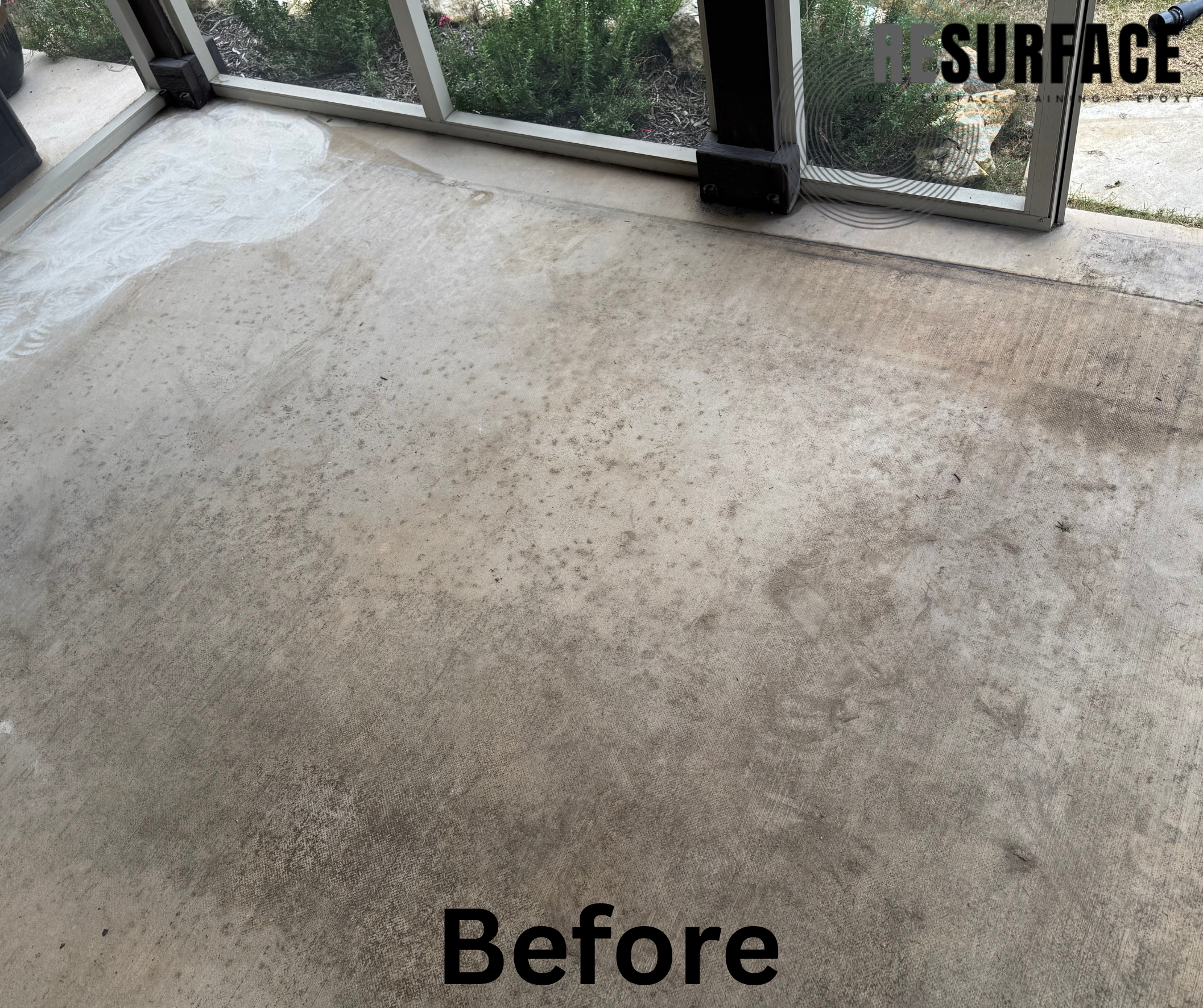 A concrete floor before cleaning or restoration, with visible stains, dust, and uneven surface patches, near a screened porch door.