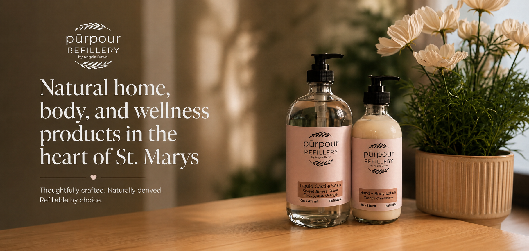 two bottles of hand lotion and soap in front of a planter with flowers with a text overlay that says "Natural home, mbody and wellness products in the heart of St.Marys"