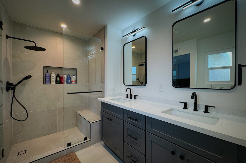 Full bathroom remodel with a walk-in shower and double vanity by Imperium Strategies Group