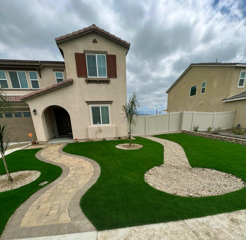 Front yard with artificial turf and curved paver walkway