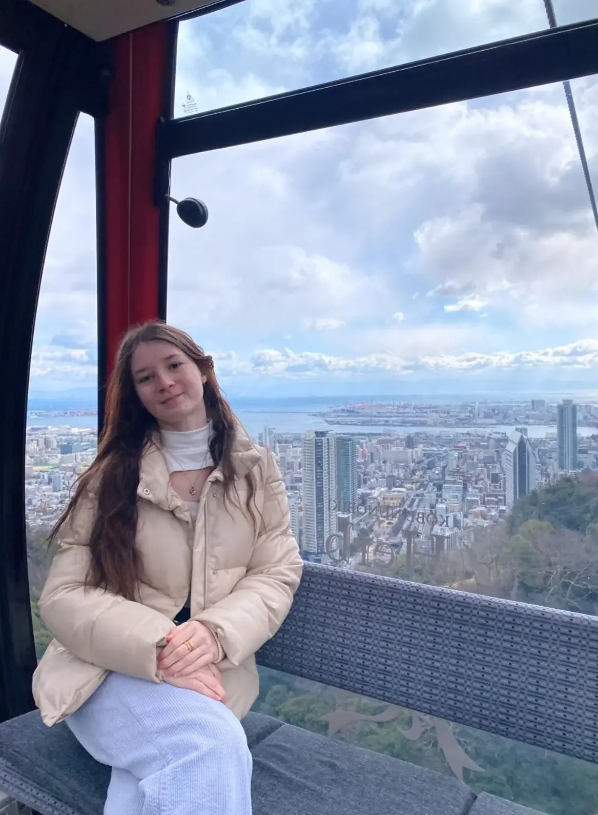 Indigo, a support worker and music student in Brisbane, seated by a window with a city view, representing creativity, wellbeing, and person-centred support.