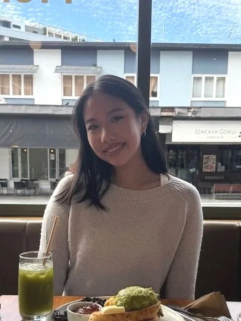 Smiling support worker seated at a café.