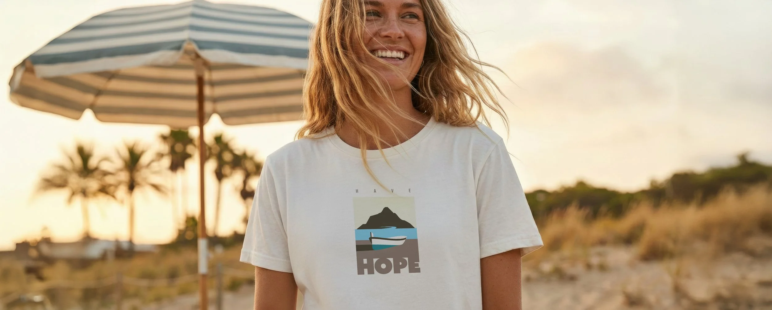 A pretty blonde girl, smiling on the beach with an umbrella in palm trees in the distance