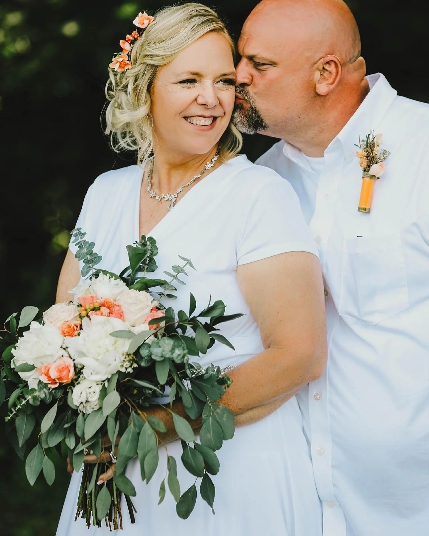 Laurie’s customers, Mariana and Carmen holding hands on a green lawn on their wedding day.