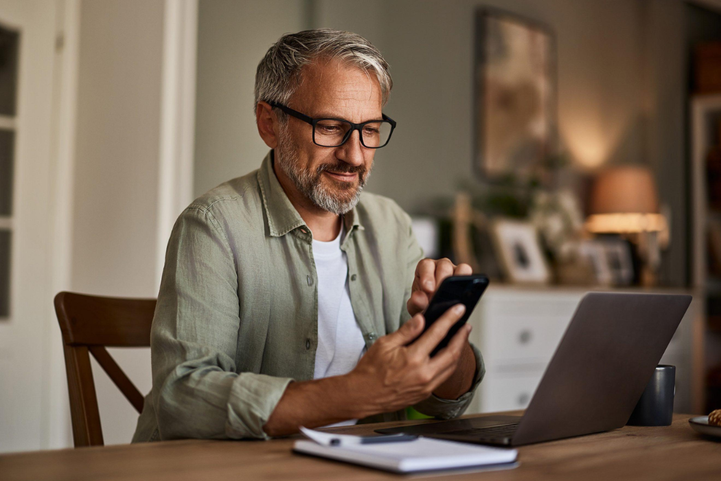 A satisfied property investor reviewing his portfolio growth on a mobile device, representing the hundreds of clients trusted by Properly Buyers Agency.