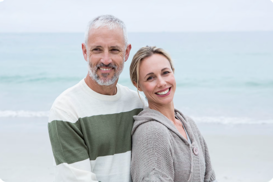 A smiling couple on a beach representing sustainable wealth and increased returns achieved with expert guidance from Properly Buyers Agency.