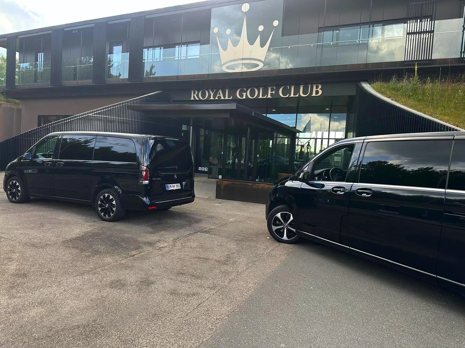 Two luxury Mercedes premium vans parked outside a golf club in Copenhagen, ready for private transfers and VIP chauffeur service