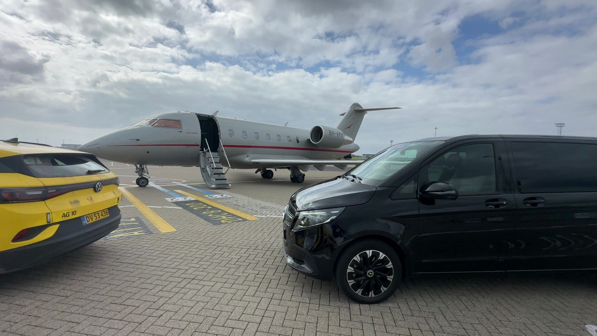 Mercedes luxury van parked airside next to a private jet during a VIP transfer at Copenhagen Airport