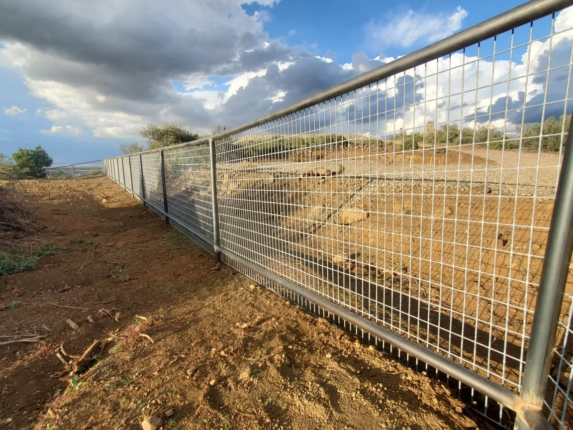 Metal fence installation along a residential property line.