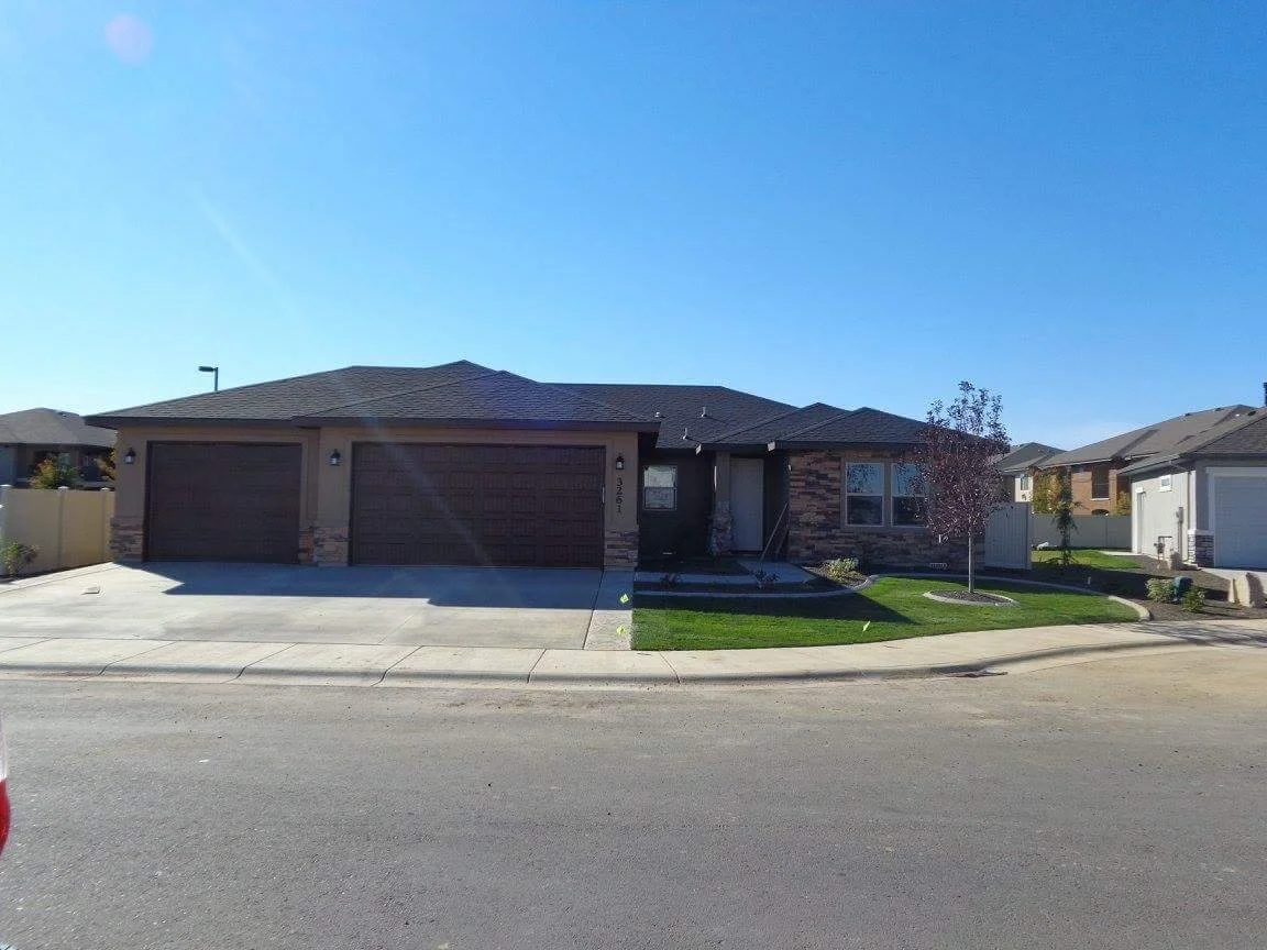 Custom home exterior with driveway, garage, and front landscaping.
