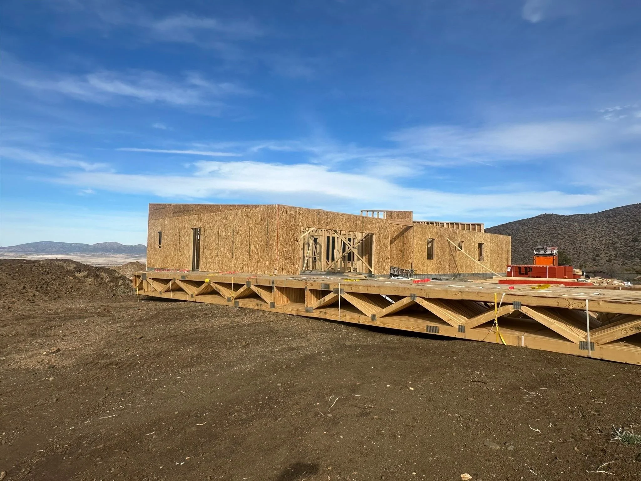 Residential home framing and construction planning on a hillside site.