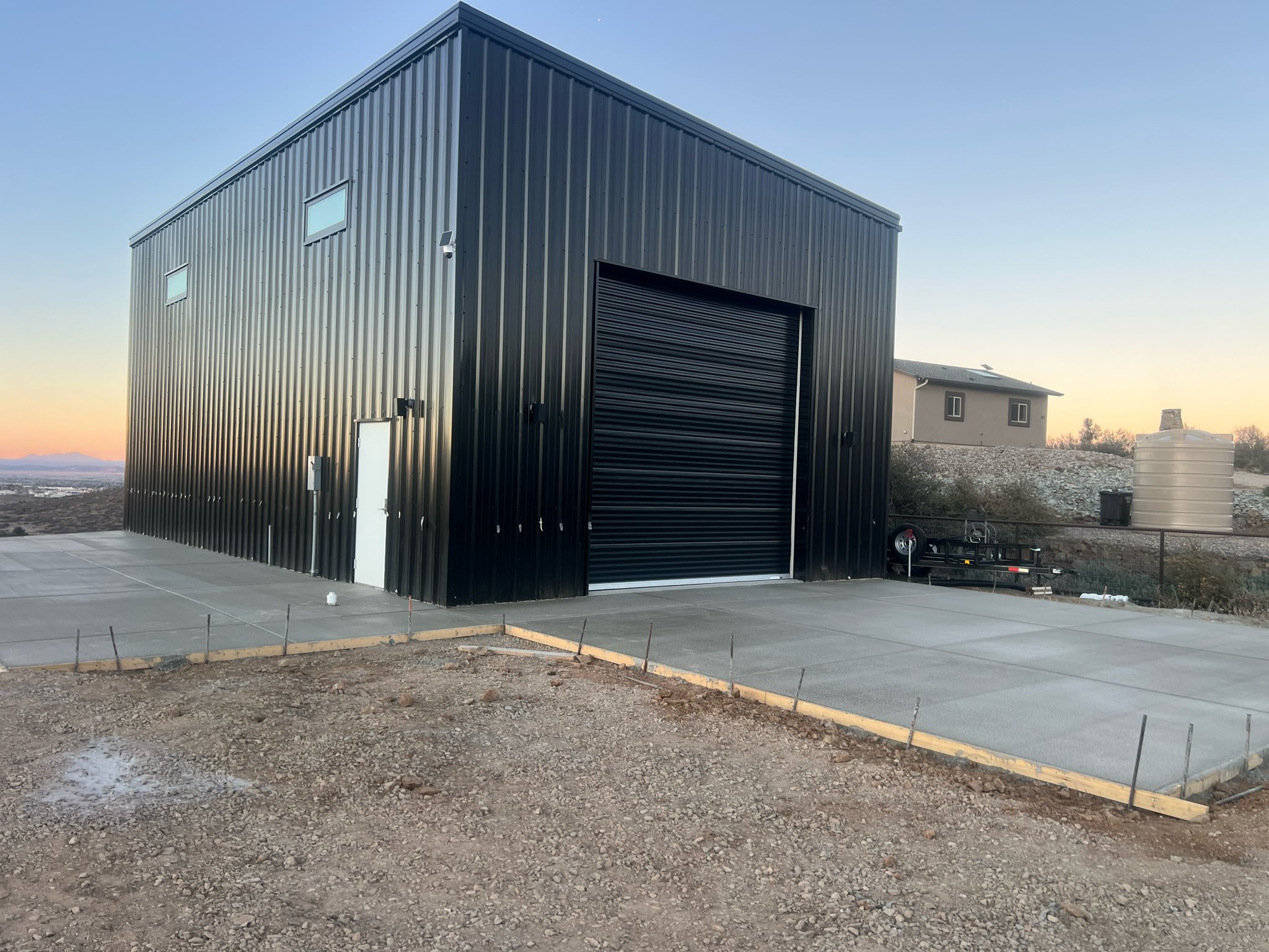 Modern Workshop Black steel workshop building with concrete apron and site improvements.