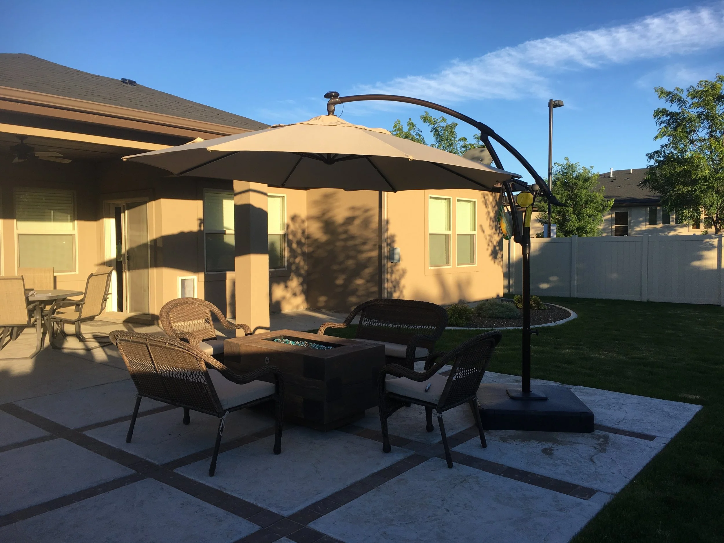 Backyard patio with hardscape, fire feature, seating, and lawn area.