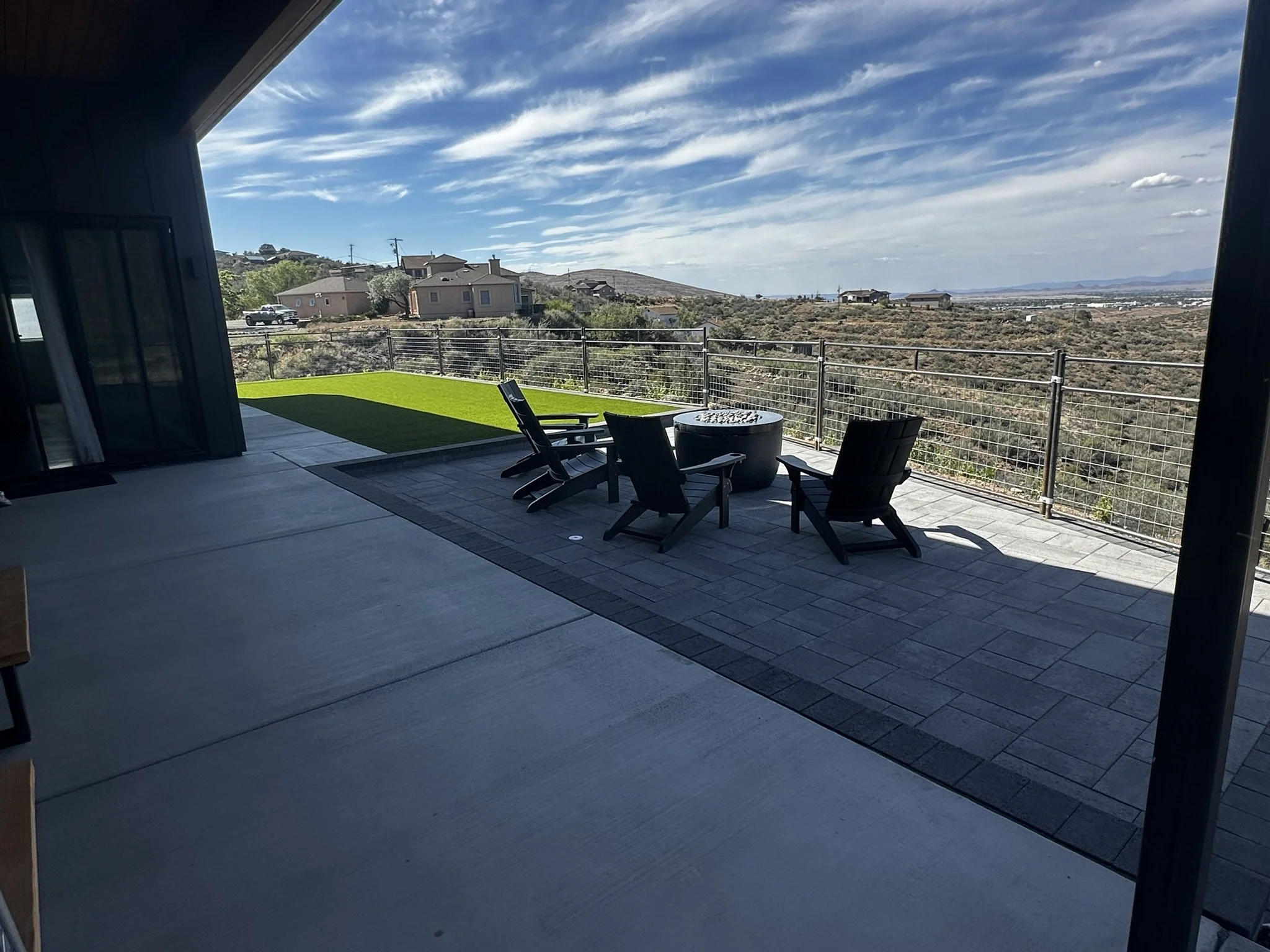Modern House Outdoor patio with seating, turf, fire feature, and mountain views.