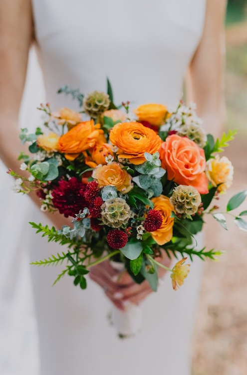 Detail images of bridal bouquet in fall colors of orange, burgundy and greenery.